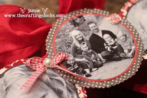 Attaching black and white family photos to a wreath with decorative brads and ribbon.