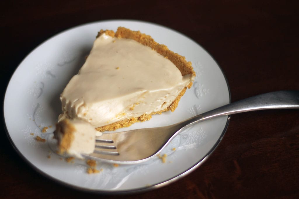 Cheesecake with graham cracker crust on a plate with a fork