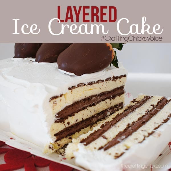 Layered Ice Cream Cake with chocolate dipped strawberries and chocolate, vanilla, and cookie layers, covered in whipped topping.