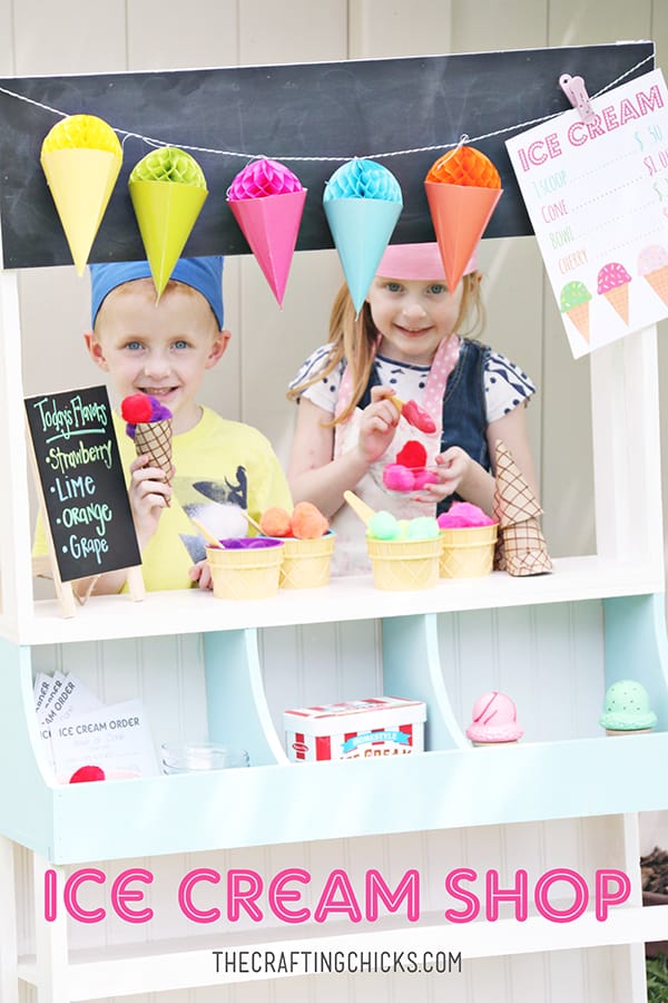 Little Boy and little girl behind a stand to sell fake ice cream cones made out of pompoms