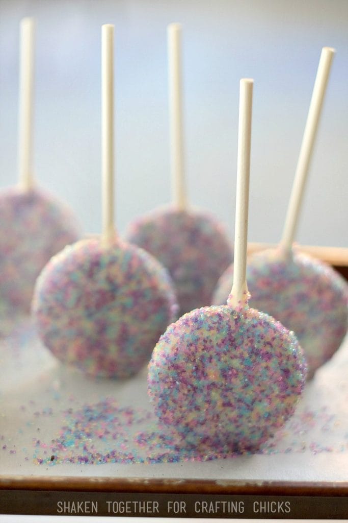Oreo pops dip in chocolate and cover with colorful sugar sprinkles - these Ball Drop Oreo Pops are ready for packaging!