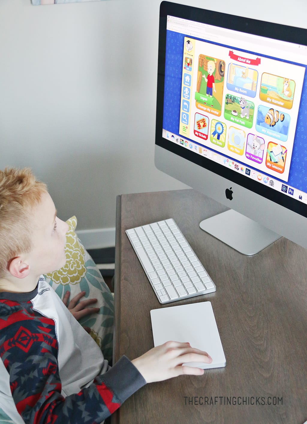little boy sitting at desk playing ABC Mouse to learn