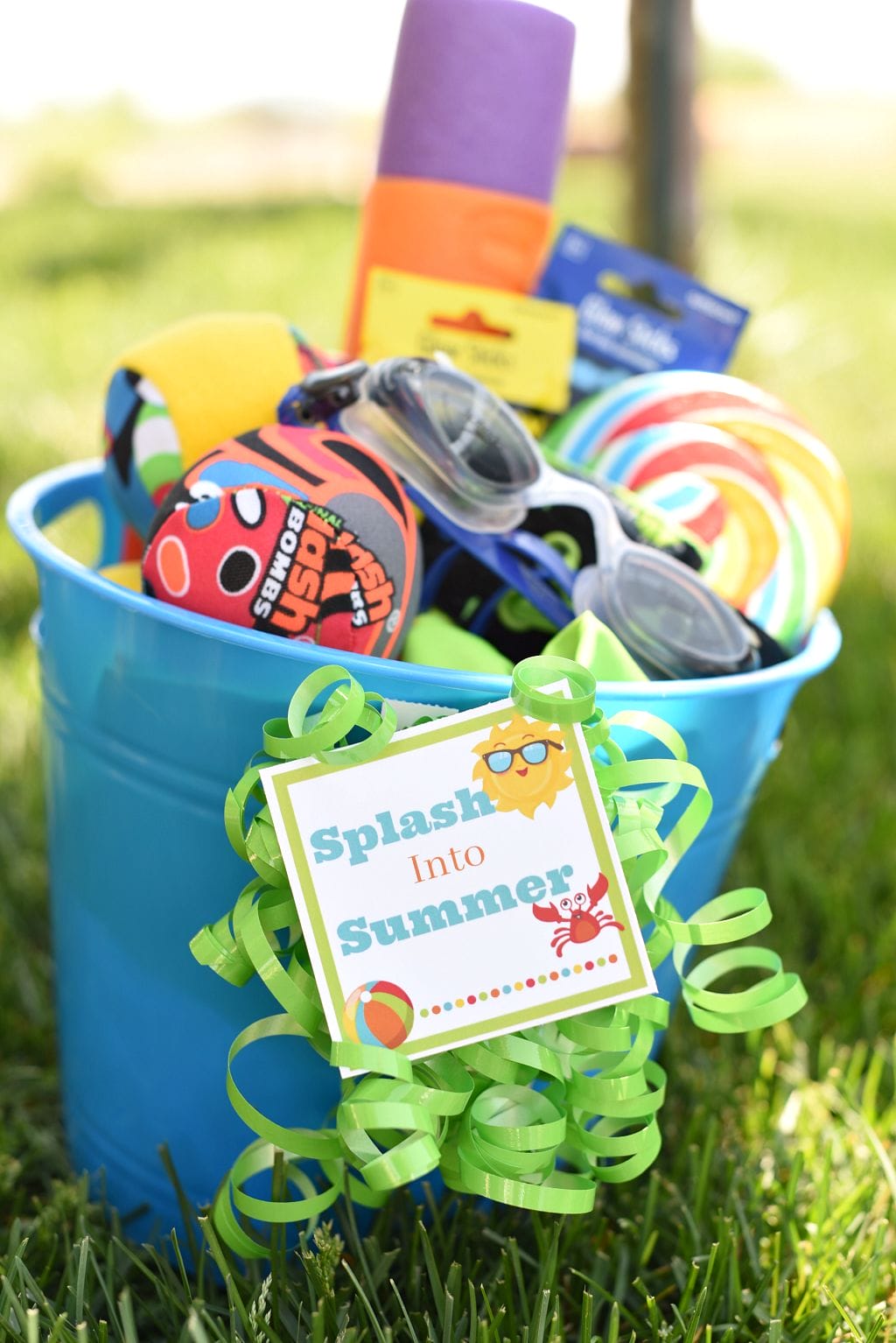 Sand bucket with water toys, goggles, and candy to make a gift.
