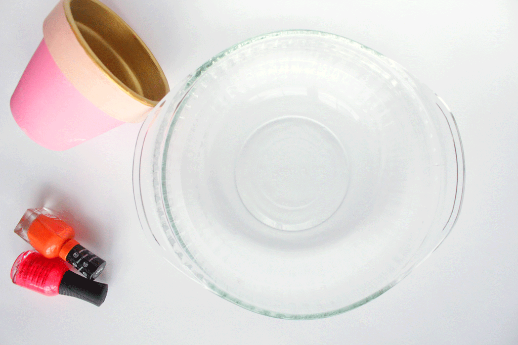 A small planter and 2 colors of nail polish and a round glass dish.