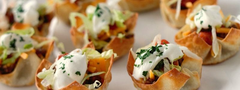 Mini Taco Cups are the perfect easy appetizer for New Years Eve or the big game! The wonton cups can be made in advance to make assembling this taco appetizer easy!