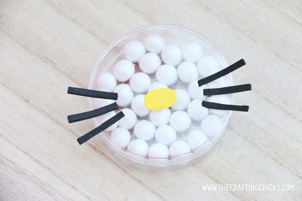 Adding a yellow nose and Black foam whiskers added to a clear round favor container filled with white Sixlets to make a Hello Kitty Face