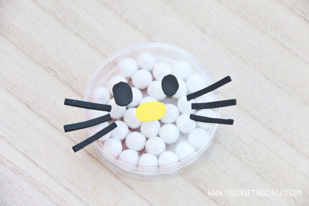 Add black foam eyes to the yellow foam nose Black foam whiskers added to a clear round favor container filled with white Sixlets to make a Hello Kitty Face