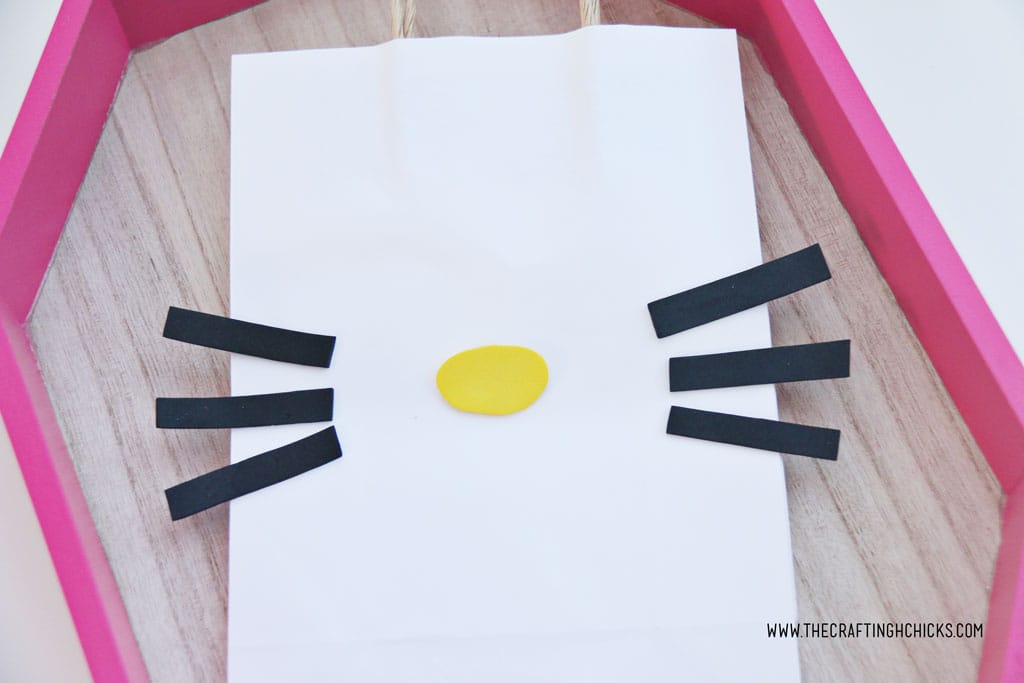 Yellow nose and black whiskers on a white gift bag to make a DIY Hello Kitty Bag