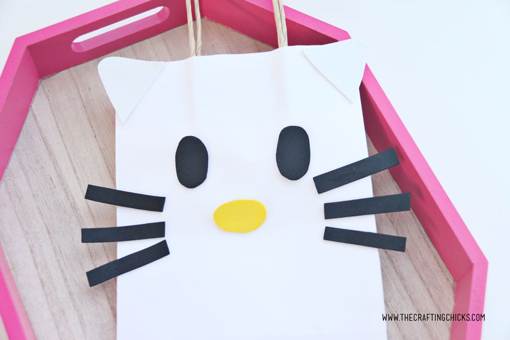 White cat ears and black eyes added to white gift bag to make a DIY Hello Kitty Gift Bag