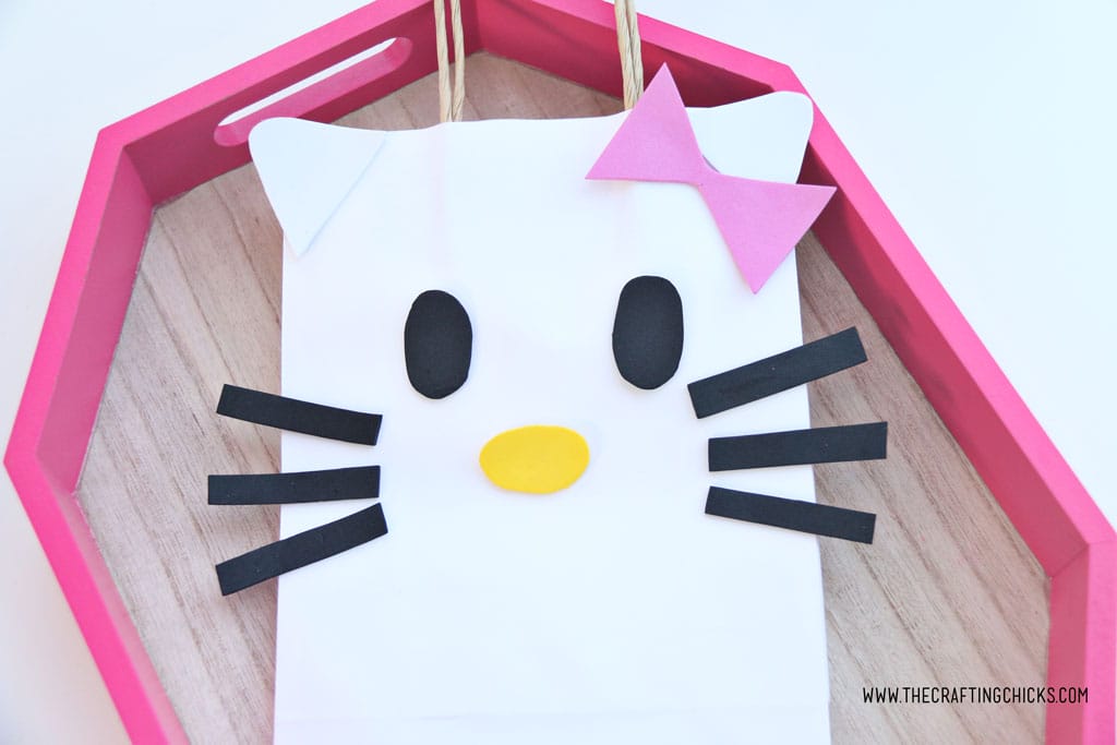 Pink bow added to white gift bag to make a DIY Hello Kitty Gift Bag