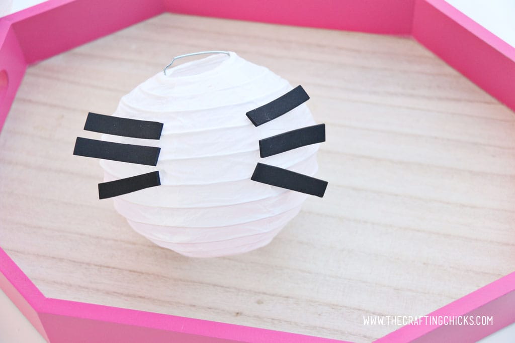 White mini paper lantern with black stripes of craft foam to make Hello Kitty DIY Paper Lanterns