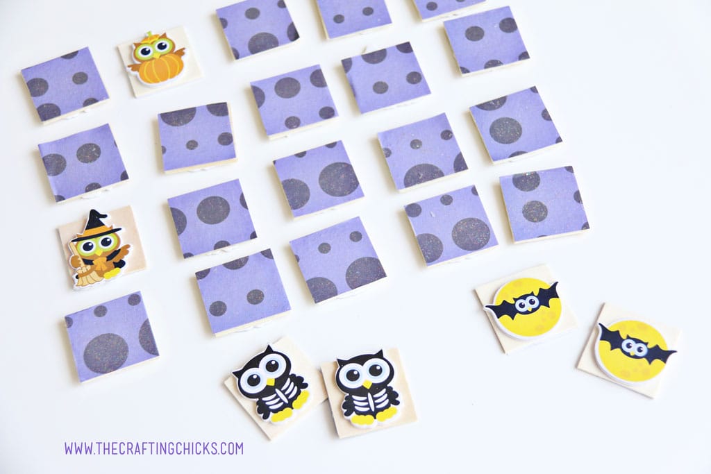 Purple paper covered wooden squares laid out for a game of Halloween Owl Memory