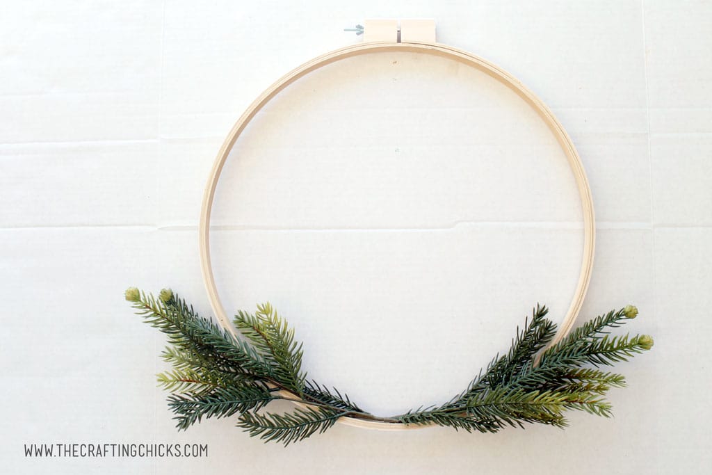 Embroidery hoop made into a wreath with faux pine branches.