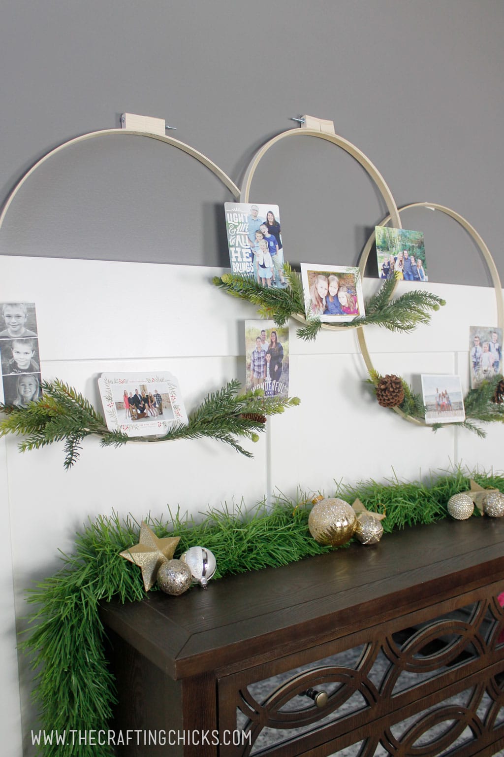 Embroidery hoop wreaths with faux pine hanging on a wall and decorated with Christmas cards