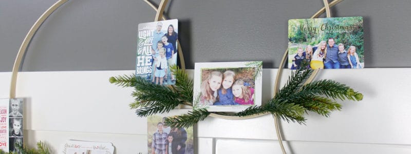 Holiday Hoop Wreath decorated with pine sprigs and Christmas cards.