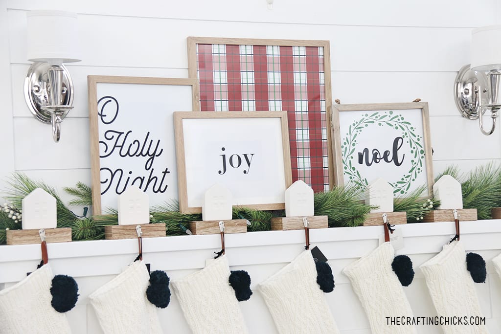 Joy print framed on a Christmas mantel with other Christmas home decor prints on a white mantel.