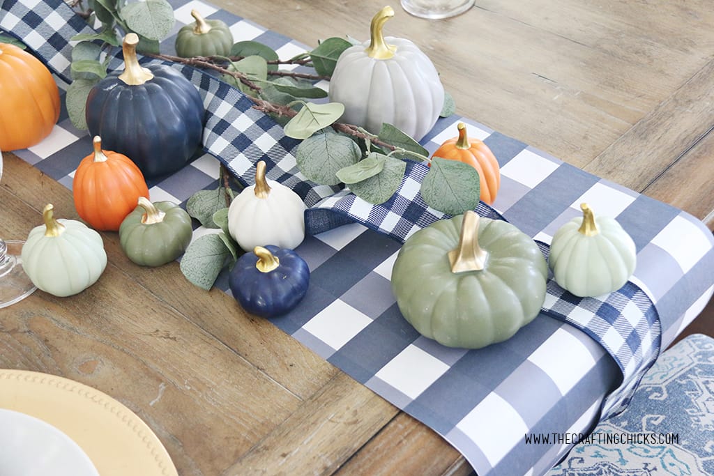Thanksgiving table with mini pumpkins and navy and white check printable table runner.