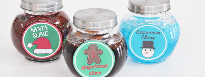 Santa Slime, Gingerbread Slime, and Snowman Slime in glass jars with lids on a white background