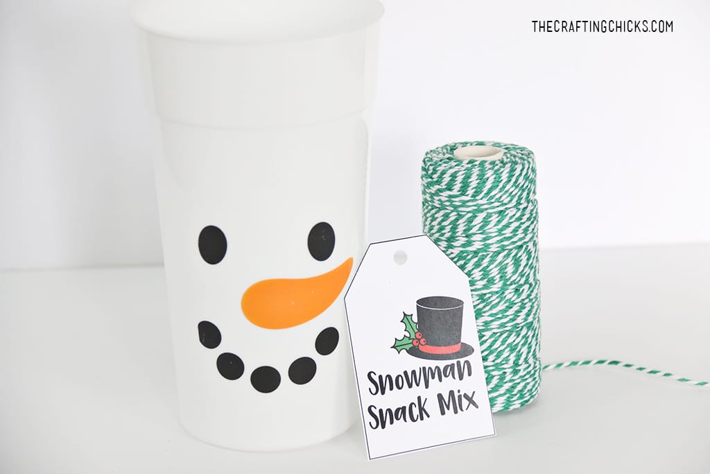 Snowman tumbler cup with gift tag and green bakers twine.