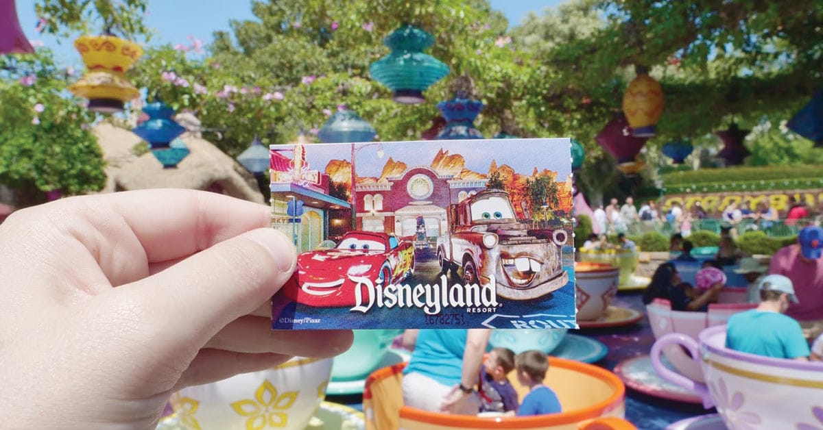 Disneyland ticket in front of teacup ride.