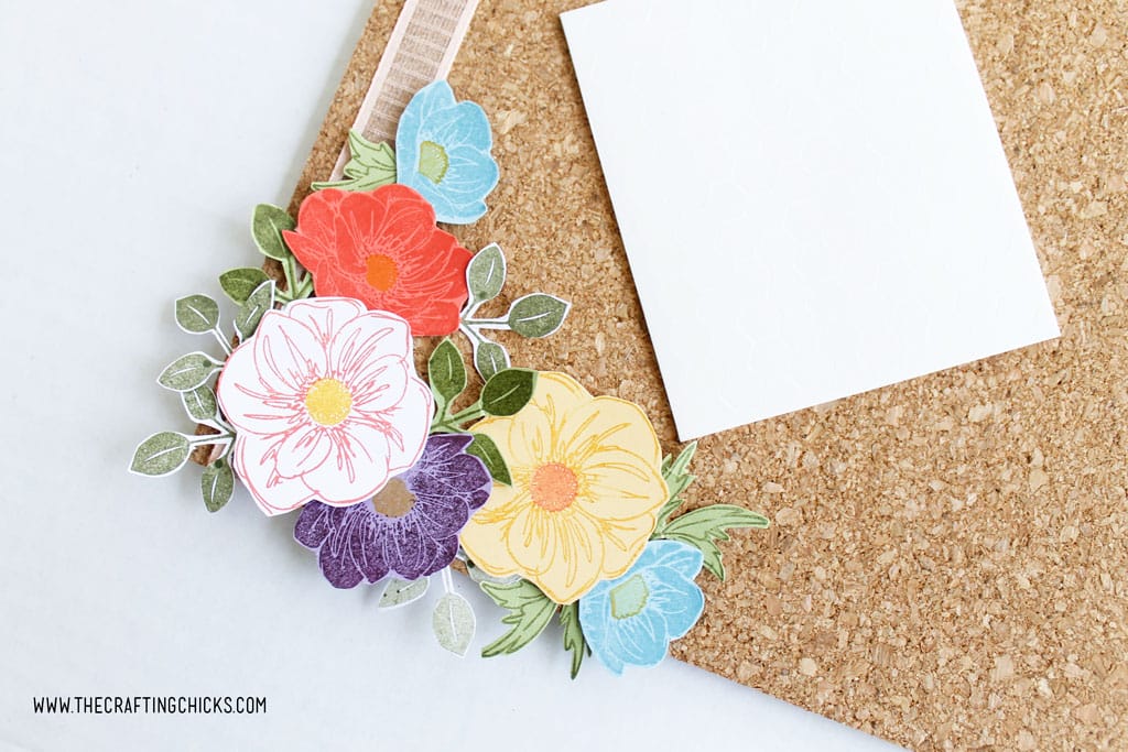 Stamped flowers layered on a cork board