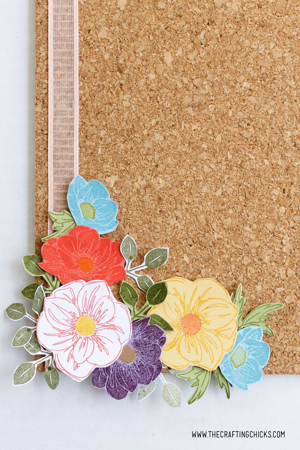 Layered stamped flowers on a cork board 