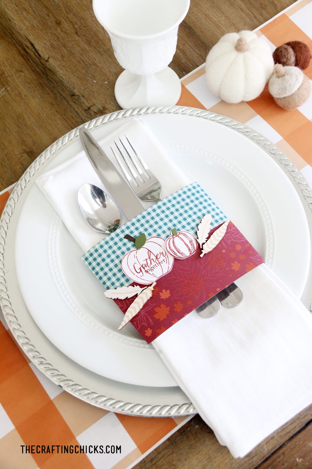 Easy Thanksgiving place setting with orange plaid place mat, white plate, and stamped napkin ring with pumpkins.