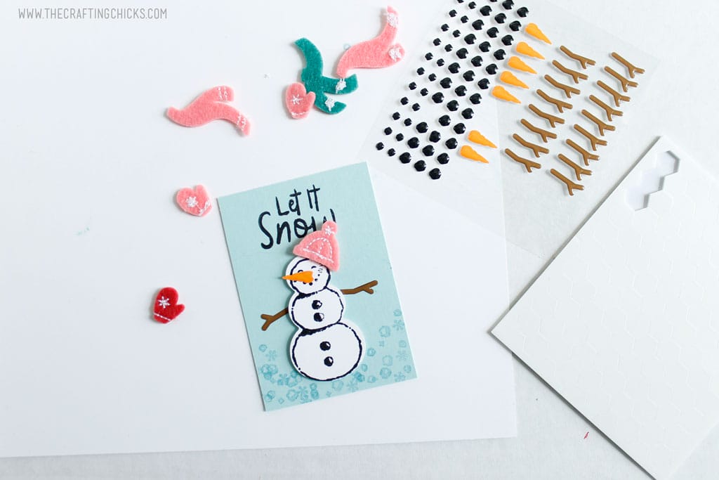Add embellishments to the stamped snowman.