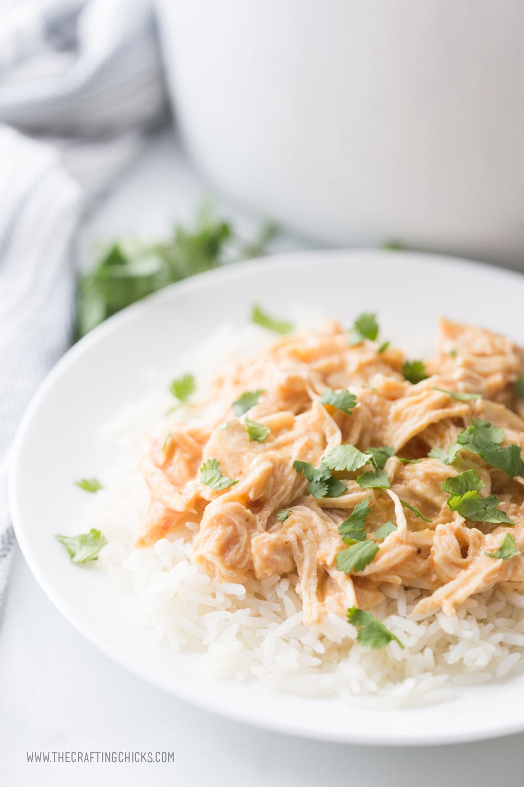 Crockpot Fiesta ranch Chicken served over rice with some cilantro sprinkled on top.