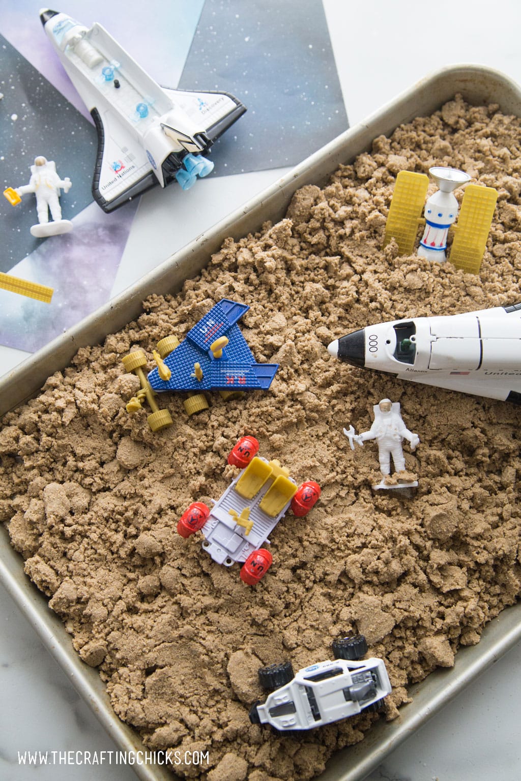 Moon sand with rocket and astronaut as play toys.