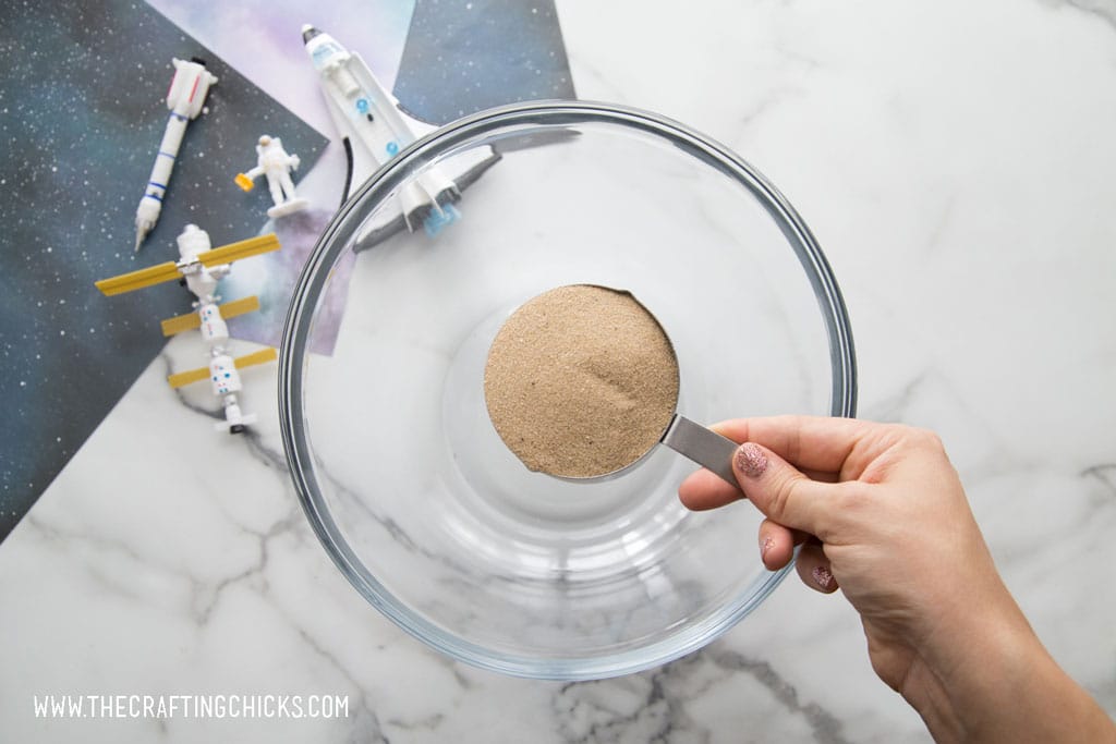 Adding fine sand to a bowl to make moon sand