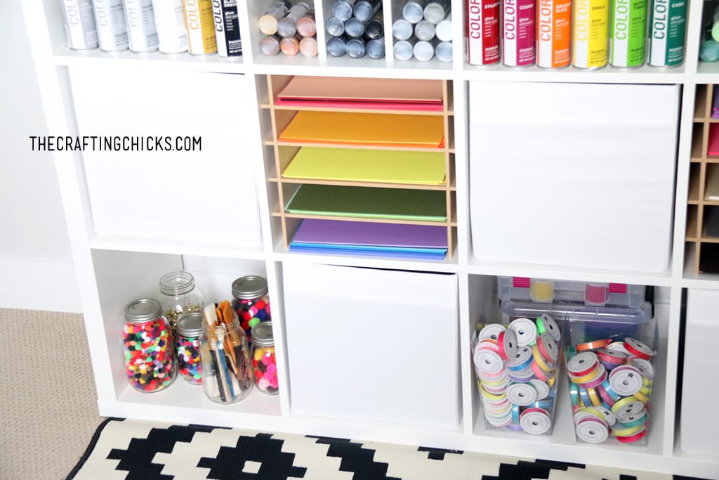 Colorful crafting supplies on a white shelf.