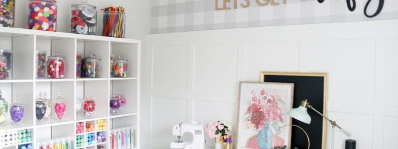 Craft Room Design with white shelves decorated with colorful crafting supplies.