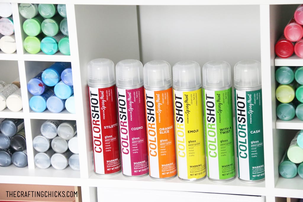 Colorful ColorShot spray paint on a white shelf.