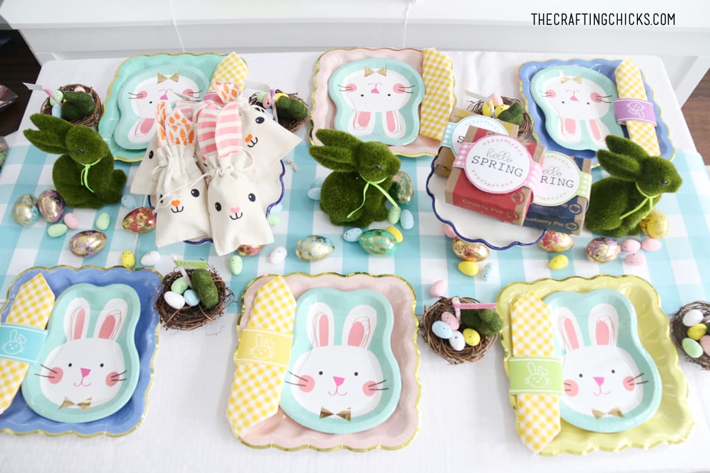 Easter table for kids with bunny paper plates, yellow gingham napkin and bunny decorations.