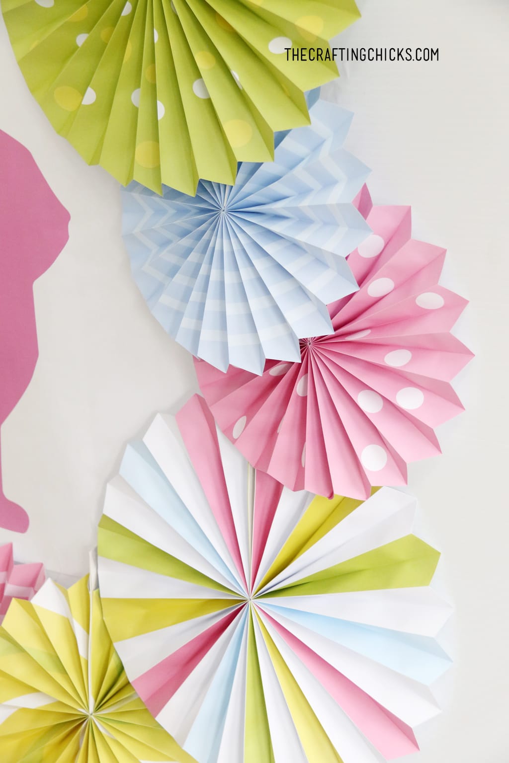 Bright colored decorative paper fans in bright green, pink, yellow and blue.