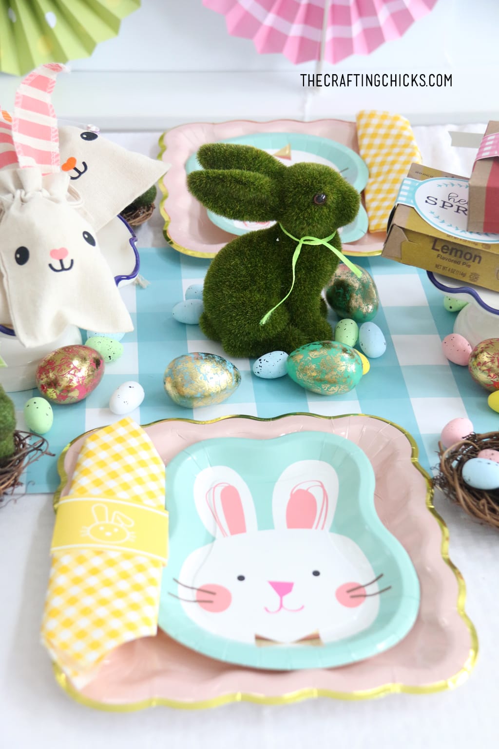 Easter table for kids with faux grass bunny decoration and faux gold foil eggs as decoration.