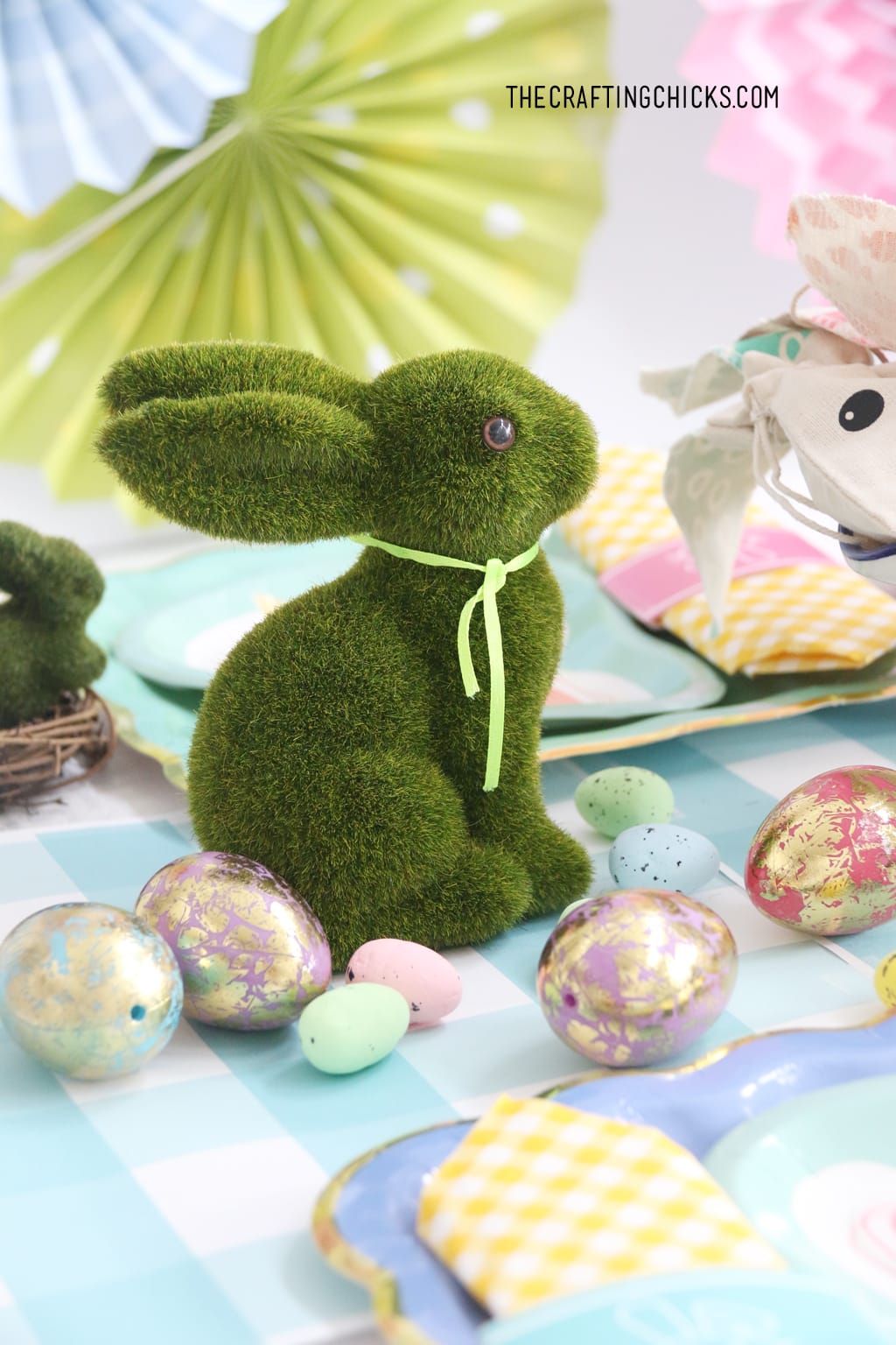 Easter table for kids with faux grass bunny decoration and faux gold foil eggs as decoration.