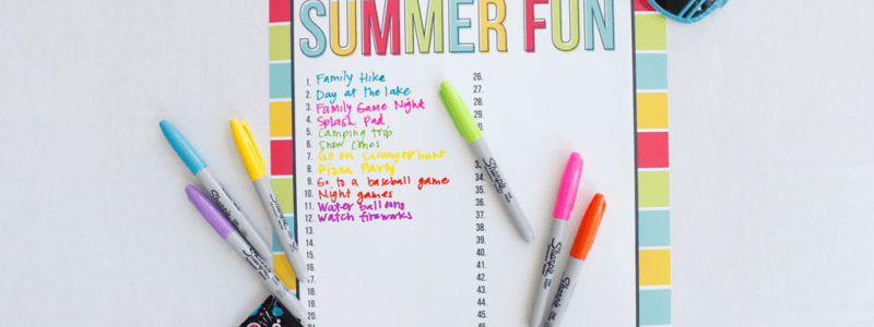 Markers and sunglasses around a poster sized printable 50 Days of Summer Fun chart