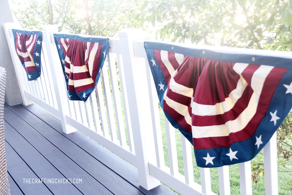 Red, white, and blue buntings hung up on the railing of a backyard deck