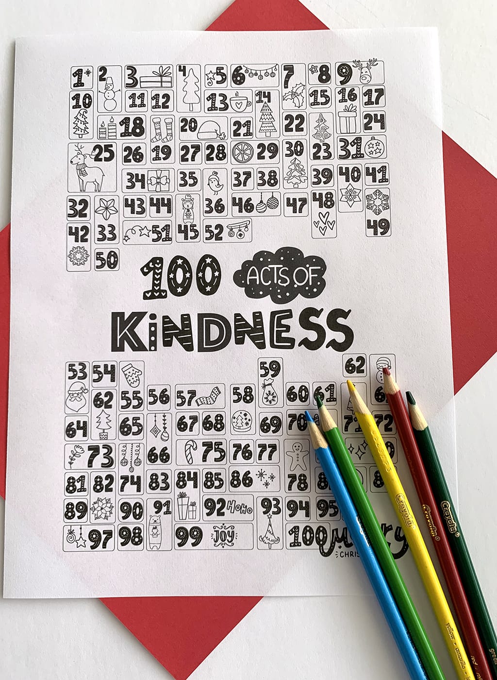 100 Acts of Kindness Coloring Countdown in black and white with a red paper under neath the print out and some colored pencils.