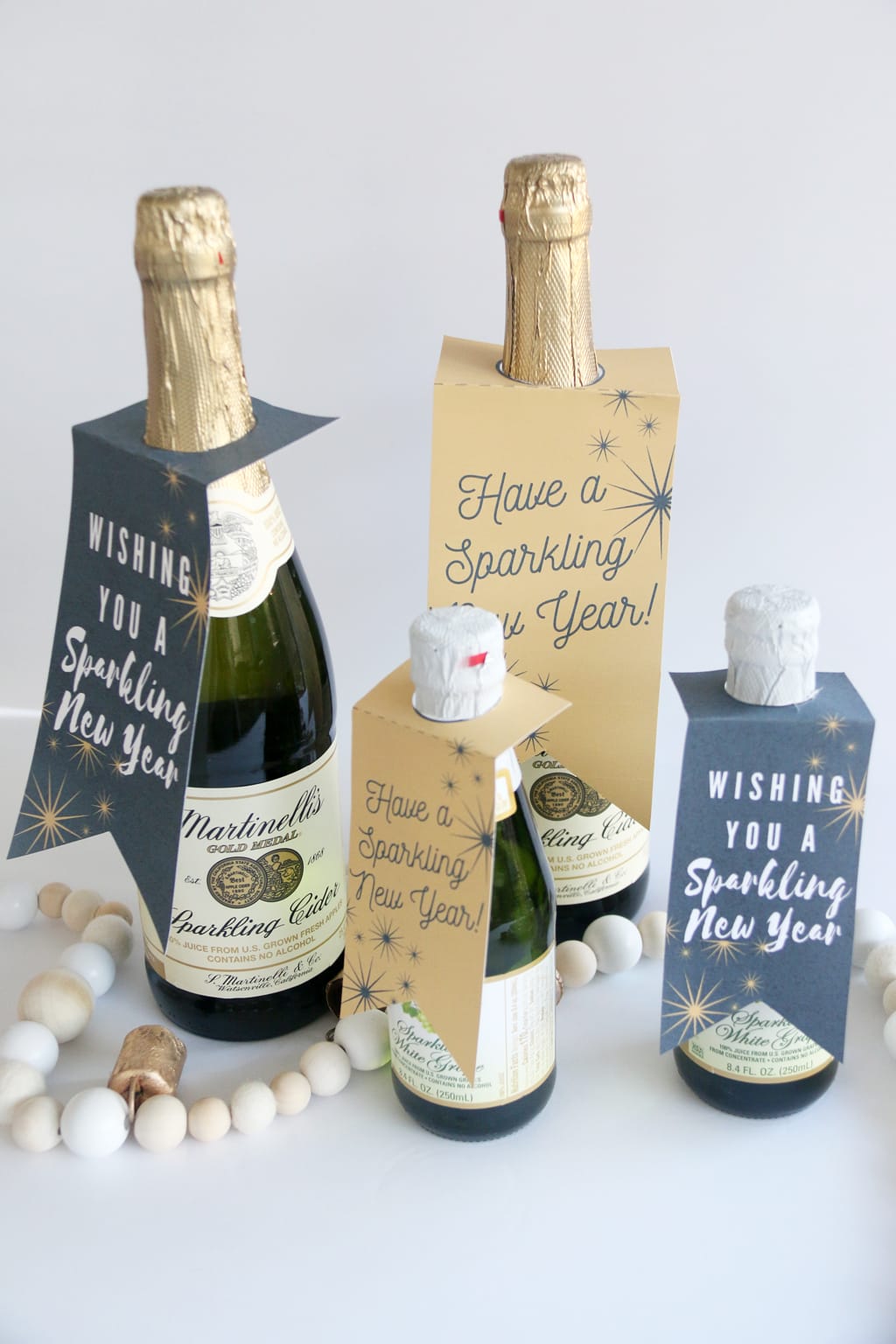Large and small bottles of sparkling cider with New Year Sparkling Cider Gift Tags on them