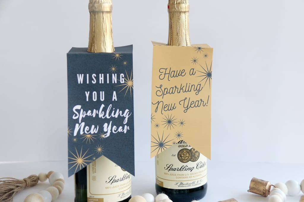 Two large bottles of sparkling cider with gift tags on them