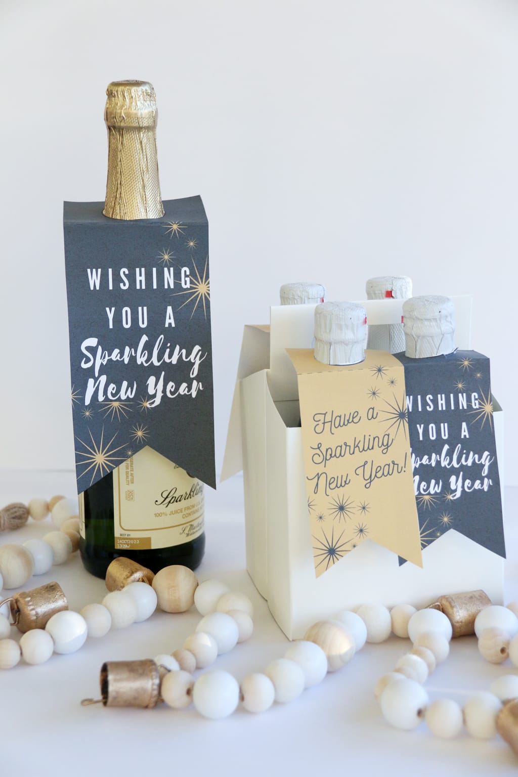 One large and drink caddy full of small bottles of Sparkling cider with New Year Sparkling Cider Gift Tags