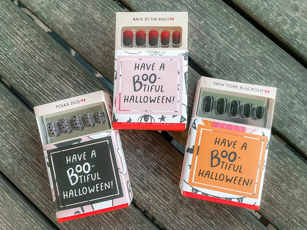 Press on nails in boxes with Halloween gift tags on them.